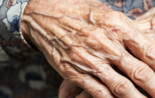 Old woman's hands folded over each other.