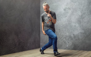 man dancing at the corner on a wooden floor.