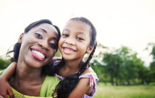 woman with her child smiling at the camera.