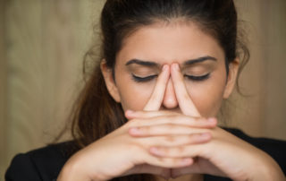 Concerned woman with black hair thinking.